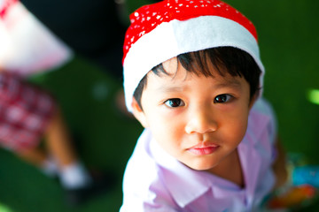 Asian boy wearing school unifrom and santa hat