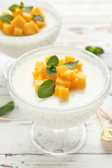 Bowl of delicious panna cotta on white table
