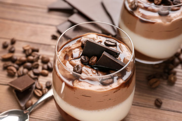 Glass of delicious panna cotta on wooden table