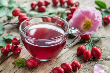 Rose-hips and rose hip seed oil on the wooden table.