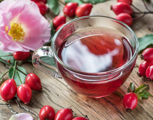 Rose-hips and rose hip seed oil on the wooden table.