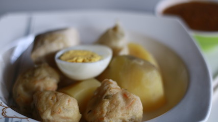 Siomay (fish cake dumplings) and peanut sauce on white background. 