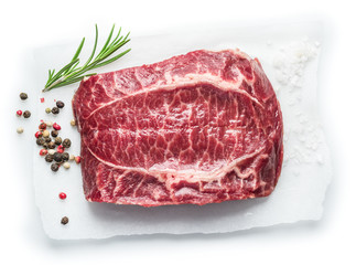 The top blade steak or beef steak with herbs and spices on white background.