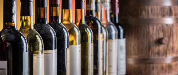 Fototapeta Wine bottles in row and oak wine keg. obraz
