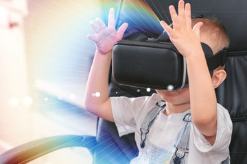 Child using new Virtual Reality, VR cardboard glasses. happy little boy with virtual reality headset sitting on sofa. Toned photo