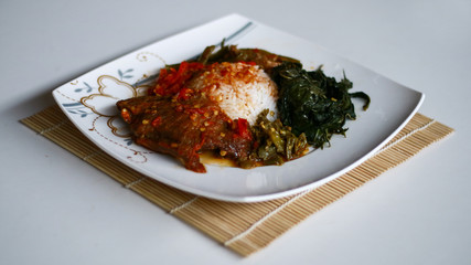 Nasi Padang (Padang Rice) with balado meat, cassava leaves, beans and chili sauce (red and green). Indonesian food from Padang, West Sumatra. 