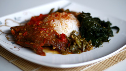 Nasi Padang (Padang Rice) with balado meat, cassava leaves, beans and chili sauce (red and green). Indonesian food from Padang, West Sumatra. 