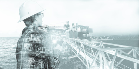 Double exposure of Engineer or Technician woman with safety helmet operated platform or plant by using tablet with offshore oil and gas platform background for oil and gas business concept