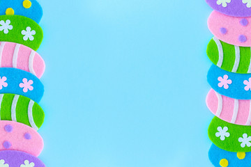 Beautiful cute easter holiday frame of handmade craft colorful eggs and blue copy space in middle. Top view flat lay color photography.