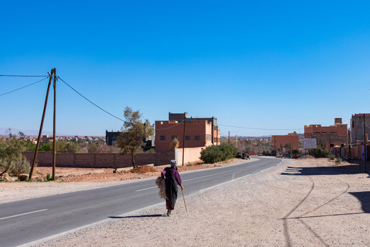 Person Walking on the side of the Road in a Rural Moroccan Town