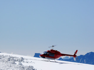 Jungfrau, Switzerland. Red helicopter on high mountain snow