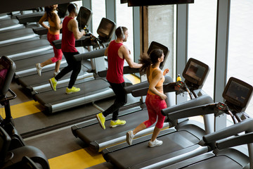 Couple run on treadmills in the gym