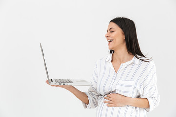 Image of young pregnant woman 30s with big belly smiling and holding laptop in hands