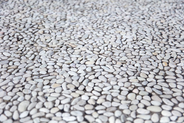 Perspective view at small round stones in the concrete wall