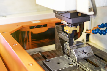 close up workpiece and graphite electrode during working on automatic electrical discharge machine (edm)