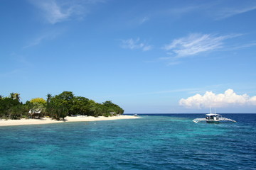 White wooden boat on deep blue sea and sky of Balicasag island snorkeling spot for coral reef, Panglao, Bohol, The Philippines