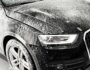 Washing black car with active foam, car wash with soap