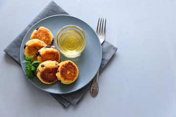 Cottage cheese pancakes with blueberry, honey, jam and coffee. Ukrainian syrniki, cottage cheese fritters or pancakes on gray wooden background. Healthy eating concept. Selective focus