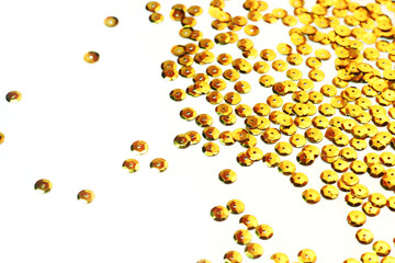 gold sequins scattered on white background