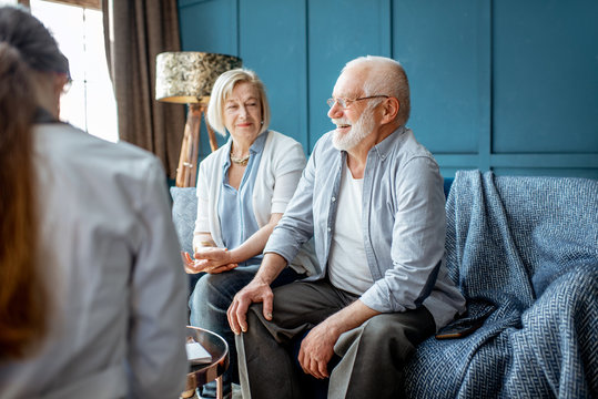 Senior Couple Sitting With Nurse During The Medical Consultation In The Comfortable Office