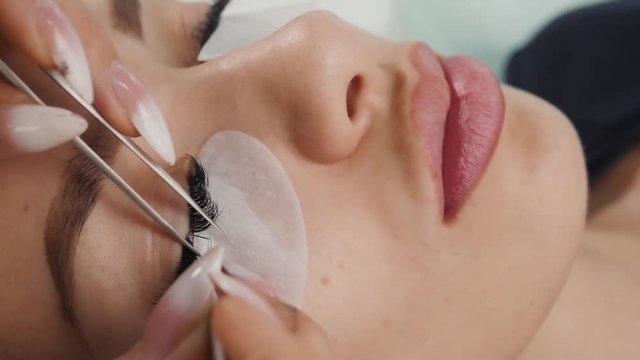 Eyelash Extension Procedure. Woman Eye with Long Eyelashes. Lashes, close up, macro treatment beauty salon