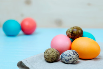 Easter painted chicken and quail eggs on a blue board. bright easter concept