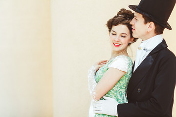 a couple in evening dress stands near the Palace