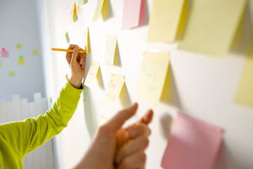 Business people write down an important note, using on the paper stickers post it. The hand of a...