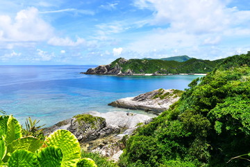Tropical paradise of green hills, white sand, turquoise sea and deep blue sunny sky at Zamami, Okinawa, Japan