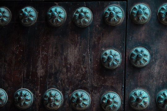 Close-up of old studded door detail with multiple decorative studs.