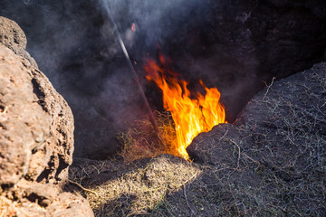 Spain, Lanzarote, Timanfaya volcano ground heat causing hot burning fire  of hay bale