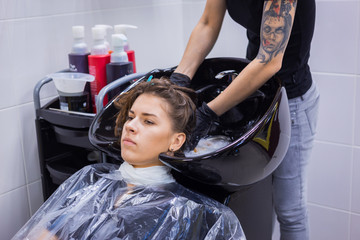 Hairdresser washing hair of woman client