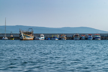 Fototapeta na wymiar Fishing Boats docked at a harbor port in Nessebar ancient city, one of the major seaside resorts on the Bulgarian Black Sea Coast. Nesebar or Nesebr is a UNESCO World Heritage Site. Boats in Nessebar