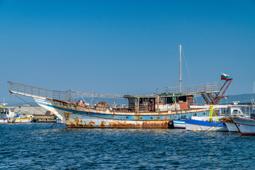 Old rusted Fishing Boat docked at a harbor port in Nessebar ancient city on the Bulgarian Black Sea Coast. Old fishing boat with rust docked at a harbor port