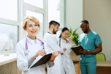 Healthcare people group. Professional female doctor posing at hospital office or clinic. Medical technology research institute and doctor staff service concept. Happy smiling models.