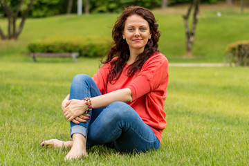The pretty woman in the park on the grass