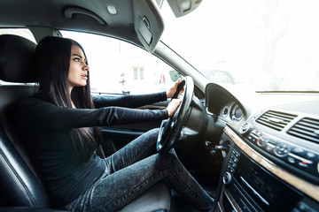 Transportation and vehicle concept. Young woman driving a car with hand on horn button