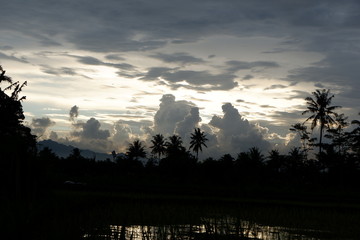 sunset view that emits sunlight against a background of cloudy sky