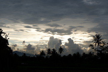 sunset view that emits sunlight against a background of cloudy sky