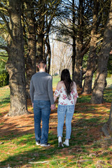 Naklejka premium Caucasian couple being affectonate among tall pine trees outdoors.