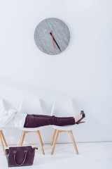 cropped view of woman lying on chairs while waiting job interview