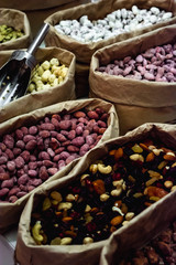 Raw nuts in paper bags at a market place. Peanuts, cashews and almonds.