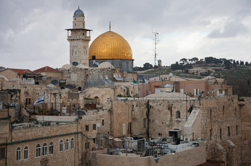 Fototapeta na wymiar The roofs of the old city of Jerusalem with the Dome of the Rock in the background in cloudy day. Israel