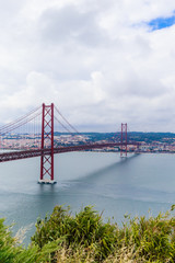 Fototapeta na wymiar Ponte 25 de Abril Bridge in Lisbon, Portugal. Connects the cities of Lisbon and Almada crossing the Tagus River. View from Almada with Lisbon across