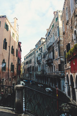 View of the Venetian canal, gondolas and boat on the water. Scenic panoramic view of Venice in winter.