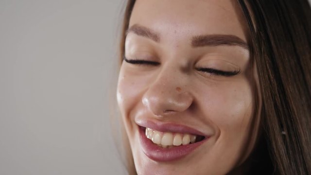 Beautiful Fashion Luxury Makeup, hyaluronic acid long eyelashes, perfect skin facial make-up. Beauty Brunette model woman holiday make up close up. Eyelash extensions, big lips false eyelashes smiling