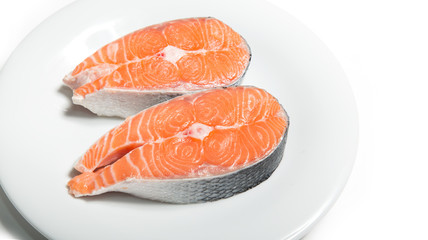 Two steaks of fresh salmon on a white plate. Raw red fish steak. Delicacy. Photos for sale of salmon and trout.
