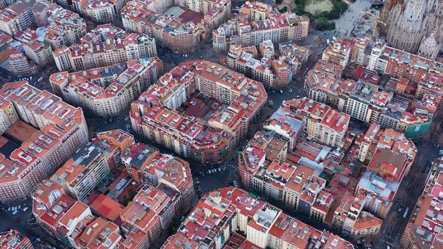Aerial view video footage of residence districts in european city. Eixample district. Barcelona, Spain. Daytime. Car road traffic