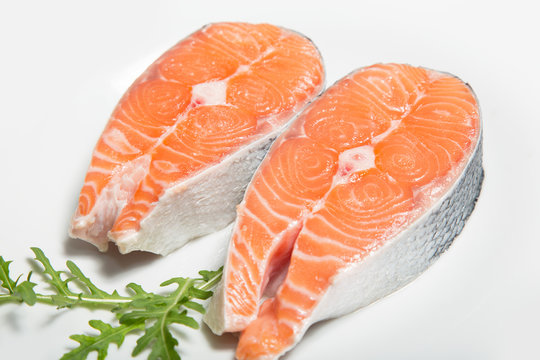 Two steaks of fresh salmon on a white plate. Raw red fish steak. Delicacy. Photos for sale of salmon and trout.