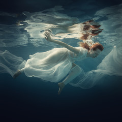 Fototapeta na wymiar Girl in a white dress under water